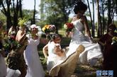 身穿新娘礼服的女人们在新娘游行活动中跃起。