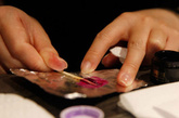 小心的将一小砣天鹅绒紫色的美甲颜料用牙签挑到锡箔纸上。