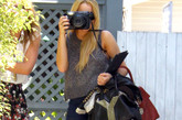 黑色的YSL皮包中间的大Y铆钉装饰十分惹眼。短裤背心的清爽造型也让Lindsay Lohan看上去活力十足。