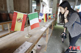 浙江青田有25万华侨遍布海外，其中主要在欧洲，因此被称为“中国离欧洲最近的县城”。而青田方山乡龙现村，全村264户1500多人，其中有一半以上侨居西班牙、意大利、法国等国家，这里也成了“中国离欧洲最近的乡村”。图为村里的吴氏家庙里，陈列着数十个国家的国旗。每一面国旗下面写着村里在对应国家工作的华侨人数。中新社发 刘关关 摄