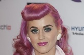 Katy Perry 把她新染的粉色头发做成50年代的复古发型，假头帘看上去俏皮可爱。唇膏的颜色为了配合头发，选择了粉红色。