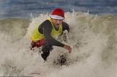 美国加州，人们扮成圣诞老人在海上冲浪，大秀绝技，引来众人围观。