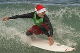 美国加州，人们扮成圣诞老人在海上冲浪，大秀绝技，引来众人围观。