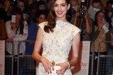 甜姐儿Anne Hathaway的通体蕾丝连衣裙优雅唯美，手上乳白色的Alexander  McQueen手包也很是抢眼。 