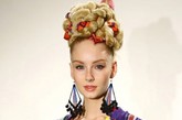 第四名：Mara Hoffman秀场

将与模特发色相近的蕾丝织物和头发，以及色彩鲜艳的丝巾一起编成“膨胀”版的麻花辫盘踞在头顶，看起来就像一顶头盔。

