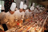 一个长达1068米的巨型树根蛋糕在上海亮相。据了解，80位厨师用了1045公斤面粉，904个鸡蛋，401公斤巧克力，633公斤鲜奶油，156张1.8米长的桌子，历时24小时打造了这只创造了新的吉尼斯世界纪录的树根蛋糕。