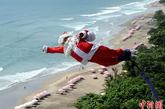 2011年12月2日，印尼库塔，一名着圣诞老人装的青年在玩蹦极。
