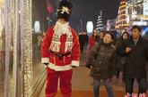 2011年12月10日，西单一家商场的工作人员打扮成圣诞老人在商场门口执行安保工作，吸引了游客的目光。

