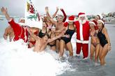 法国尼斯，圣诞老人下海洗澡，美女们左拥右抱成为一道亮丽的风景线。