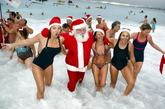 法国尼斯，圣诞老人下海洗澡，美女们左拥右抱成为一道亮丽的风景线。