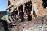 水平村村民阿炳（左一）与女儿、邻居及贺派乡党委书记唐青华（右二）一起在她家的新房前整理砖头和施工材料。