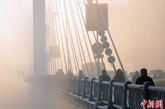 12月27日，吉林市松花江畔再次出现雾海奇观，临江门大桥和两岸的建筑物笼罩在大雾中若隐若现，犹如海市蜃楼。中新社发 王明铭 摄 图片来源：CNSPHOTO 
