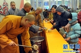 少林寺僧人在施粥现场给市民们盛粥（图片来源：新华网  摄影：王颂）