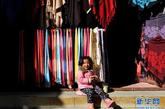 这是一名小女孩坐在云南香格里拉独克宗古城的一家店铺门口玩耍（2月1日摄）。位于海拔3300多米的云南省迪庆藏族自治州香格里拉县的独克宗古城，始建于唐朝，距今已有1300多年的历史。“独克宗”藏语寓意为“月光城”，和丽江一样曾是滇藏“茶马古道”上的重镇。近年来，随着旅游业的发展，当地加强了对独克宗古城的保护和修缮工作，重现了这一具有独特民族文化特色古城的历史风貌。如今独克宗古城已成为香格里拉县的精品旅游景点，吸引着越来越多的海内外游客前来旅游观光。新华社记者蔺以光摄 

