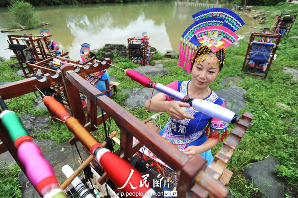 7月3日，在广西靖西县旧州村，壮族姑娘在织锦。（郑重声明：凡带有“人民图片”字样图片，未经许可，不得转载。购图电话010-65368421）