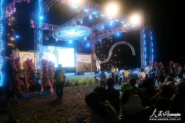 海边搭建的舞台，吸引了很多人前来观看演出。（人民网张希 摄）