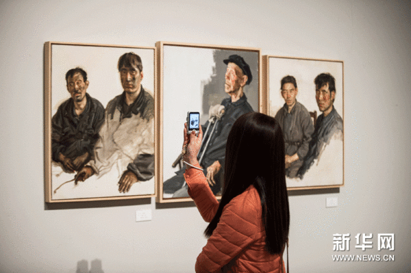 一名参观者在拍摄画家陈丹青的人像作品。