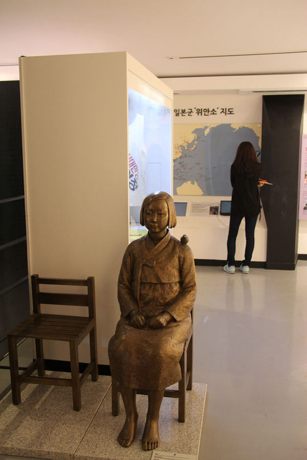 　　博物馆内陈列的慰安妇受害者铜像和正在观看展览的参观者。(记者万宇/摄)