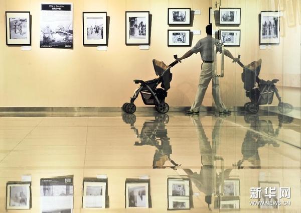 （5）6月18日，参观者在首都图书馆观看“一百年前的北京社会”——西德尼·甘博摄影图片展。　　
