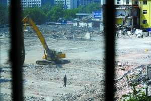 　　5月13日，六里桥如家酒店拆迁现场，一位保安在挖掘机前巡逻。该酒店当天被法院强拆。本报记者 杨杰 摄