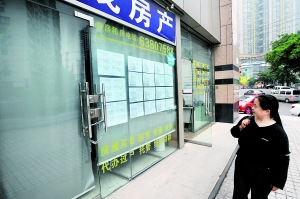 24日，重庆市渝中区一家大门紧闭的房产中介。 记者杨新宇摄